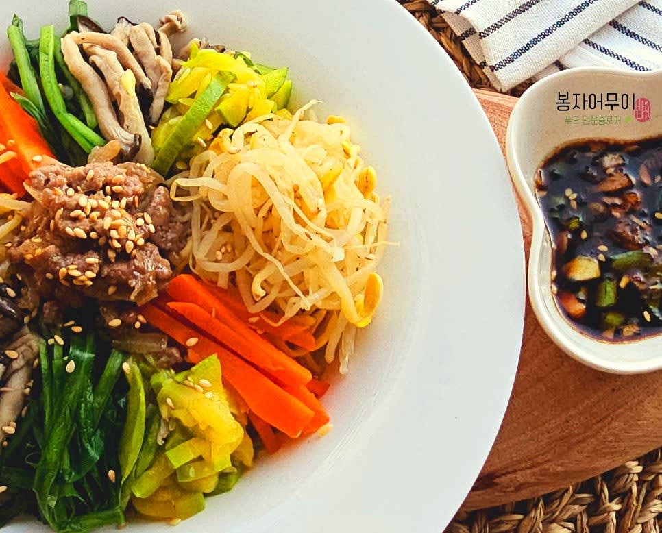 밥 위에 무친 콩나물, 볶은 소고기, 준비한 양념장을 적당히 얹고 비벼서 완성합니다.