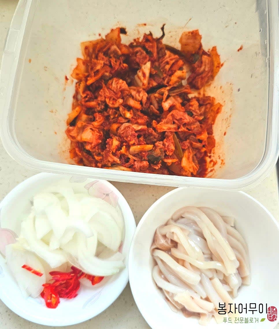 김치와 오징어, 양파, 청양고추를 섞어주고 한 쪽으로 밀어 둡니다.