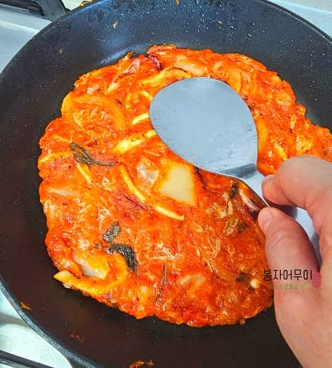 김치와 오징어가 골고루 섞이도록 잘 올리고, 뒤집어 눌러서 바삭하게 만듭니다.