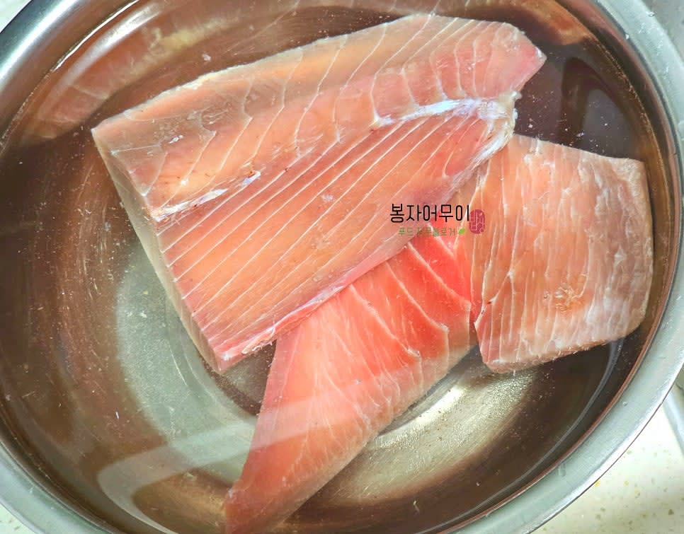 냉동 참치 포장을 뜯어 물 1L에 소금 2스푼을 넣고 5분 정도 담가 불순물을 제거하고 해동 및 소독을 합니다.