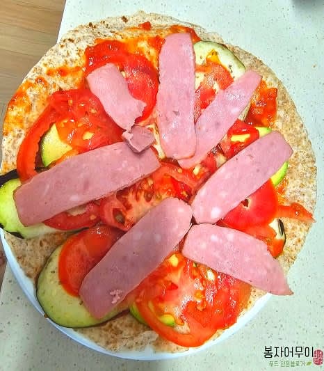 썰어둔 야채와 햄을 또띠아 위에 올립니다.