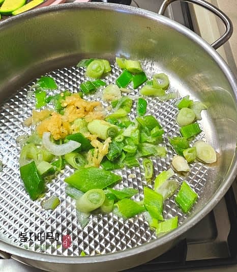 팬에 참기름을 두르고 대파와 마늘을 넣어 볶아 향을 냅니다.