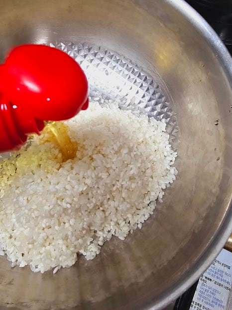 팬에 참기름 2스푼을 두르고 세척한 쌀을 넣어 약불에서 볶아줍니다. 쌀이 약간 투명해지면 물 1.5L를 부어줍니다.