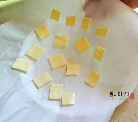 종이 호일에 약간의 간격을 두고 자른 치즈 조각을 올립니다.
