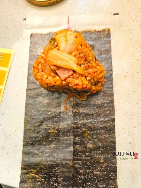 삼각김밥용 김에 볶음밥을 올리고 삼각김밥 틀을 사용해 단단히 눌러줍니다.
