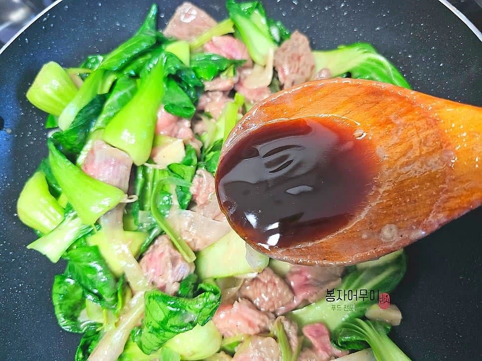 청경채를 넣고 굴 소스 1스푼을 추가하여 골고루 섞으며 간을 합니다.