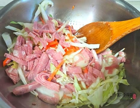 마늘 향이 올라오면 양배추와 베이컨, 우동을 넣고 함께 볶아줍니다.