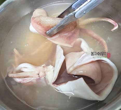 물을 끓여 맛술 1스푼을 넣고 오징어를 1분간 데친 뒤 찬물에 헹궈 식혀줍니다.