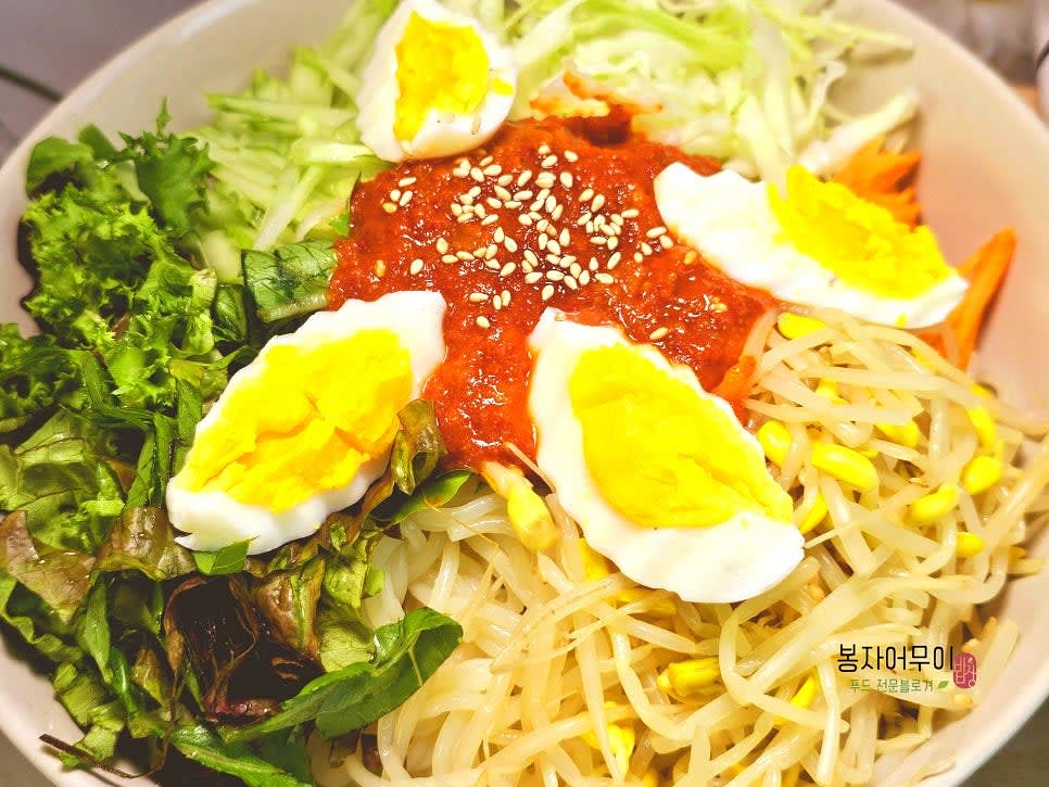 삶은 쫄면과 데친 콩나물, 준비한 야채를 볼에 담고 양념장을 섞어 골고루 비빕니다.