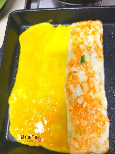 흰자를 다 말고 나면 노른자를 팬에 부어 흰자 위에 이어서 구워줍니다.
