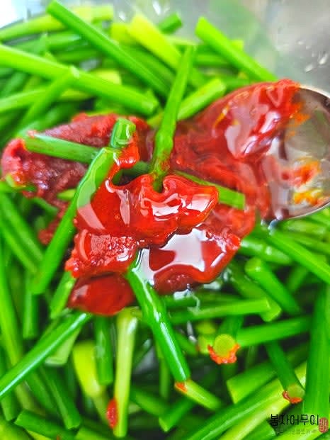 마늘쫑 고추장 무침을 준비합니다. 데친 마늘쫑에 고추장, 물엿, 깨소금을 넣고 조물조물 무칩니다.