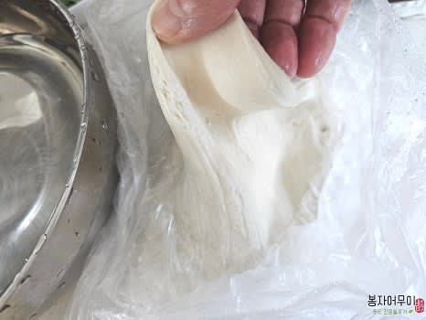 반죽을 뜯어 육수에 넣고, 선택적으로 냉동만두를 추가합니다.