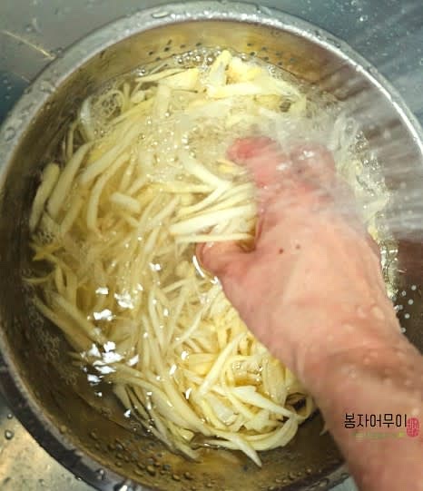 깐 도라지를 준비해 굵은 소금 한 스푼을 넣고 문질러서 쓴맛을 제거하세요. 손으로 문지른 후 여러 번 세척하며 물에 헹궈주세요.