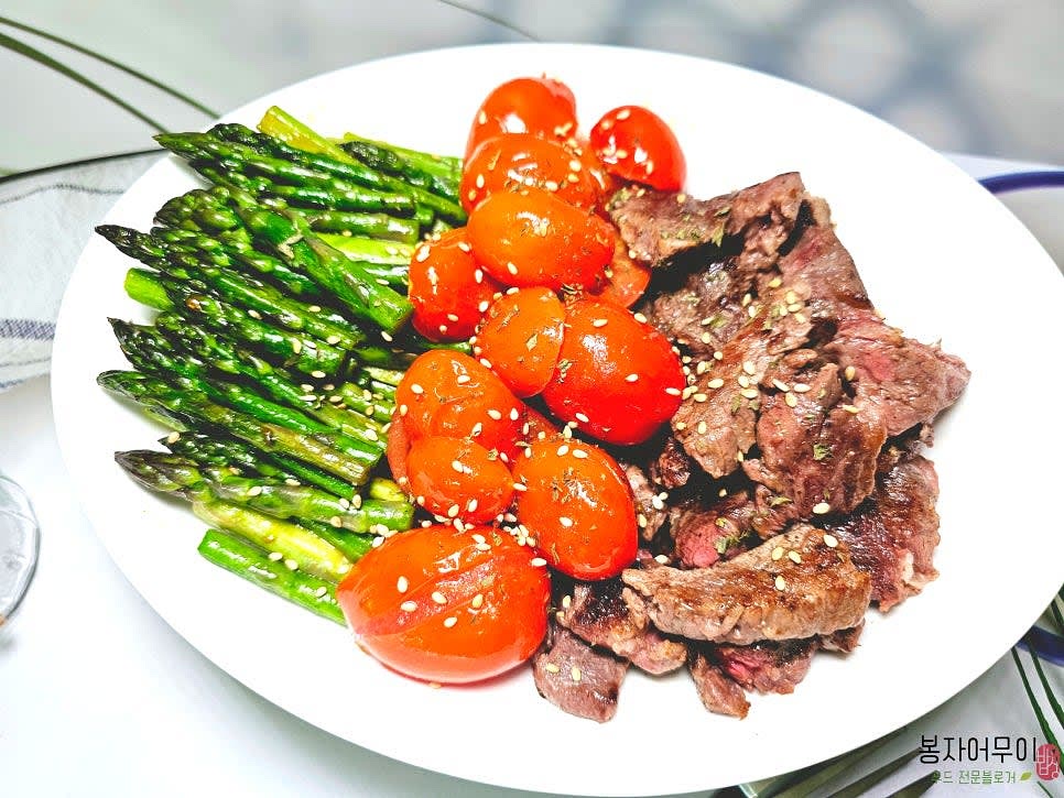 소고기와 아스파라거스, 토마토를 함께 접시에 담아냅니다.