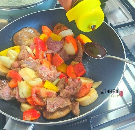 소고기가 앞뒤로 살짝 익으면 야채를 살짝만 볶다가 스테이크 소스를 섞어줍니다.