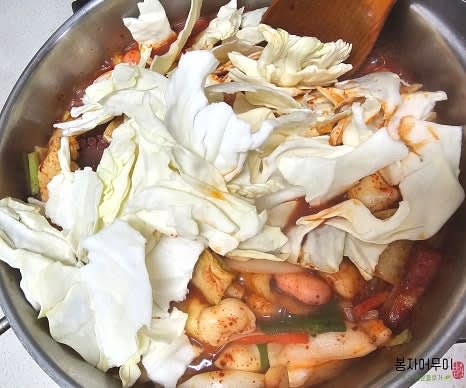 어묵과 라면을 살짝 삶은 뒤 모든 재료를 넣어 조리하며 떡볶이를 완성합니다. 떡과 자숙 문어 다리, 양배추, 라면 등을 넣고 맛있게 보글보글 끓이면 완성입니다.