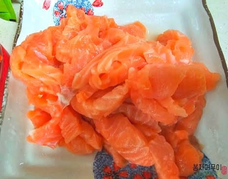 소독한 생연어를 흐르는 물에 헹구어서 물기를 털고 먹기 좋은 크기로 썰어 골고루 뿌려줍니다.