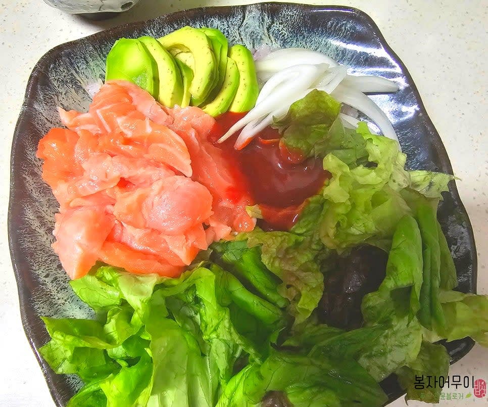 밥 1공기를 그릇에 담고, 그 위에 야채와 양파, 아보카도를 3등분으로 나누어 골고루 올린 후 시판 초장을 뿌려줍니다. 초장의 양은 취향껏 넣어주세요.
