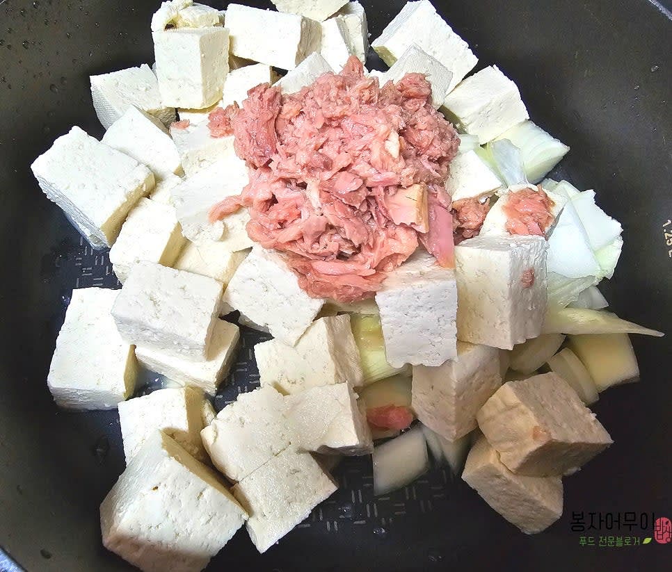 냄비에 참치, 두부, 썰어둔 양파와 대파를 넣습니다.