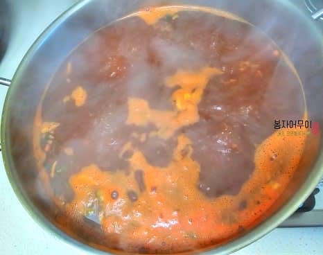 냄비에 물을 끓이고 신라면 스프를 넣은 후 라면 사리, 문어 다리(통째로), 양파, 다진 대파를 넣습니다.