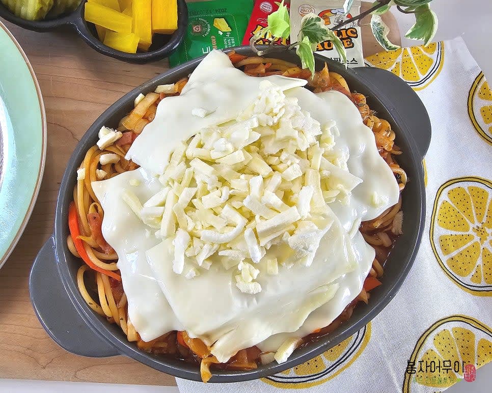 스파게티 면을 넣고 함께 볶다가 치즈를 듬뿍 올리고 파슬리 가루를 뿌립니다.