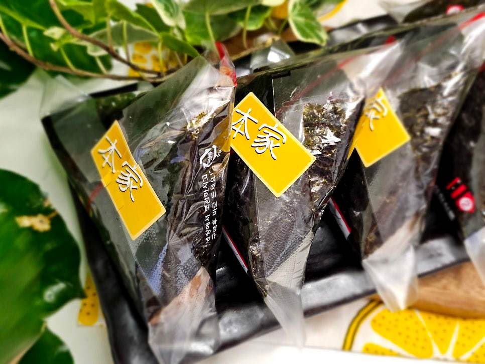 삼각김밥용 김으로 감쌉니다. 김이 잘 붙도록 끝부분을 물로 살짝 적셔 고정합니다.