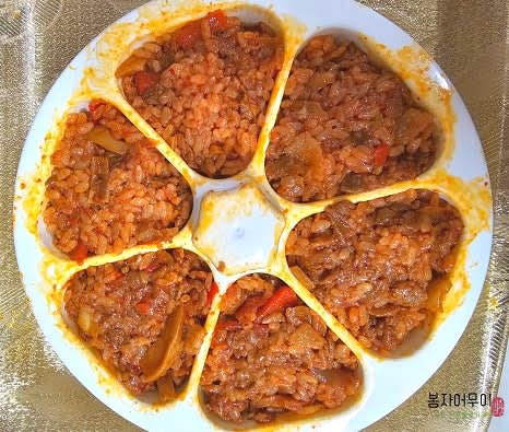 삼각김밥 틀을 준비합니다. 틀 안에 밥을 반 정도 넣고, 밥을 골고루 눌러 담습니다.