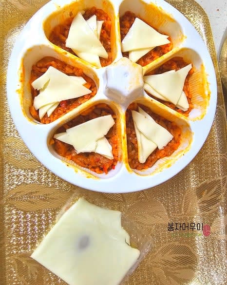 밥 위에 치즈 한 장을 작게 잘라 올립니다. 치즈는 삼각김밥 속에 들어갈 수 있도록 적당히 잘라 사용합니다.