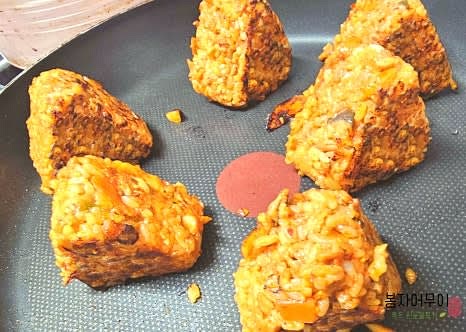 프라이팬 또는 오븐을 이용해 삼각김밥의 겉면을 살짝 구워줍니다. 약불로 천천히 굽거나 오븐에서 5분 정도 구워 겉면을 노릇하게 만듭니다.