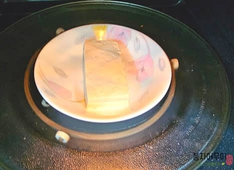 두부는 전자레인지에 물을 살짝 뿌려 1분 30초간 돌려 부드럽게 만든 뒤, 물기를 제거합니다.
