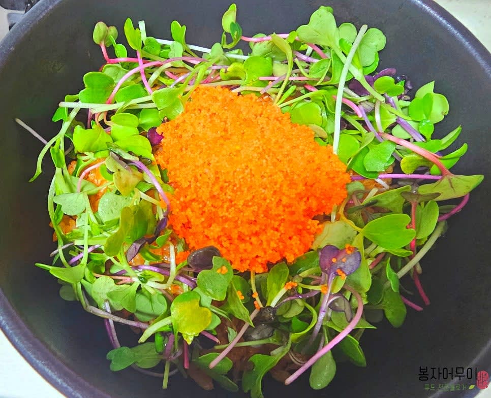 뚝배기에 김치볶음밥을 1인분씩 담고 날치알과 새싹채소를 가볍게 올립니다.