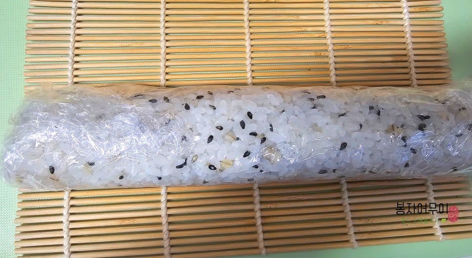김밥을 돌돌 말아 비닐로 싸고 꼭꼭 눌러줍니다.