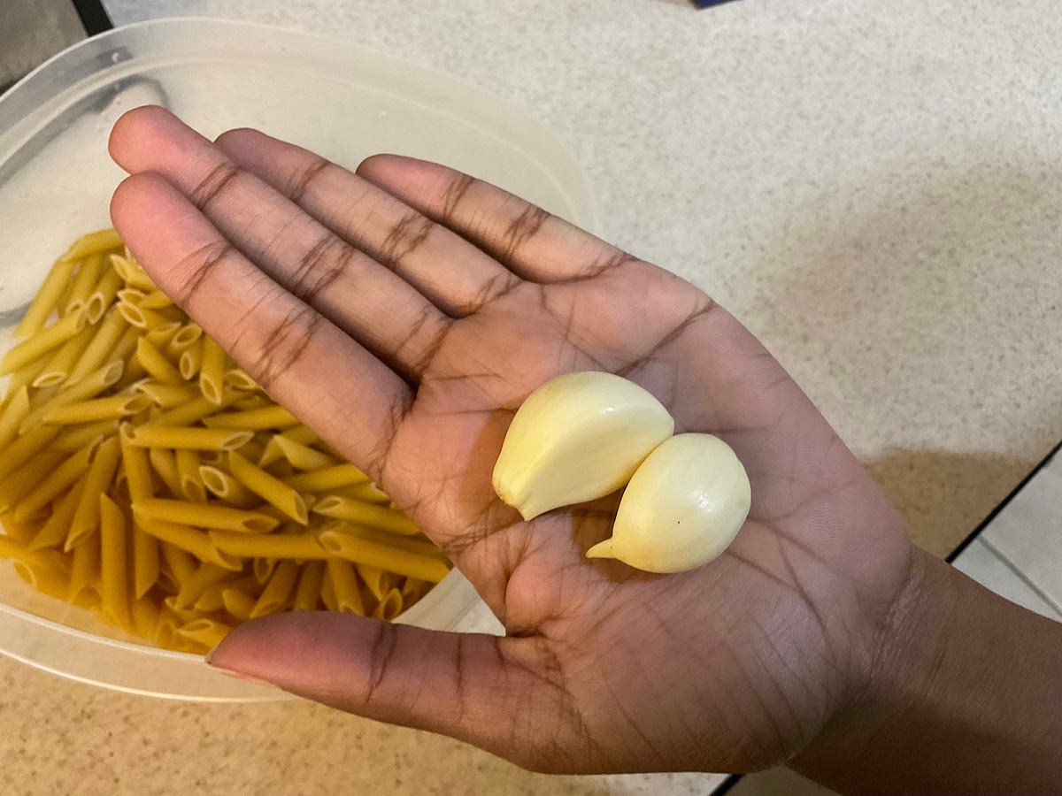 To the water, add two cloves of garlic, cut lengthwise along with 1 tsp of water