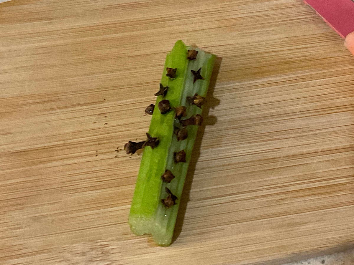While the pasta is boiling, take a piece of celery and stick cloves into it