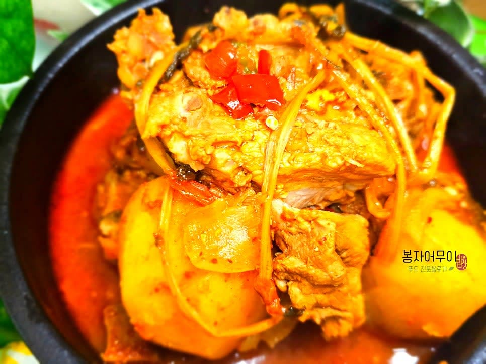 완성된 감자탕을 그릇에 담고 깻잎을 얹어 장식하여 따뜻하게 서빙합니다.