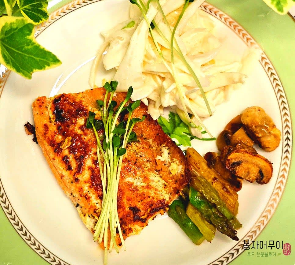 연어구이에 채소와 소스를 곁들여 서빙합니다.