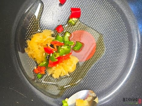 프라이팬에 참기름과 콩기름을 두르고 약불로 가열합니다. 다진 마늘과 썰어둔 청양고추를 넣고 약불에서 천천히 볶아 향을 냅니다.