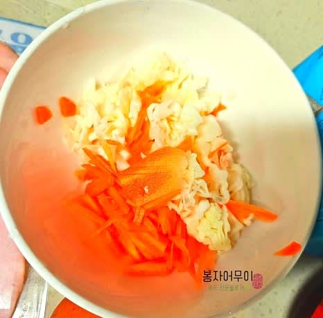 양배추를 잘게 채 썰어 식초물에 잠시 담갔다가 세척하고 물기를 빼줍니다. 당근도 채 썰어 준비합니다.