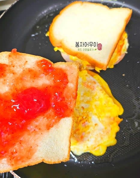 빵 한 면에 딸기잼을 바르고 그 위에 구운 계란을 올립니다.