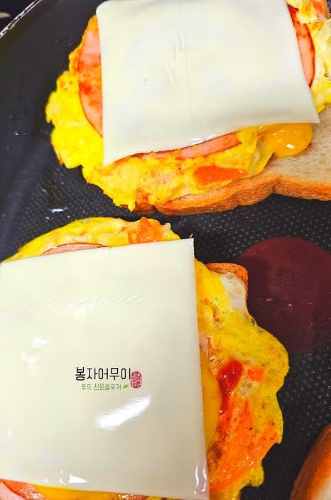 그 위에 햄 2장과 슬라이스 치즈 1장을 얹고 다시 빵으로 덮습니다.