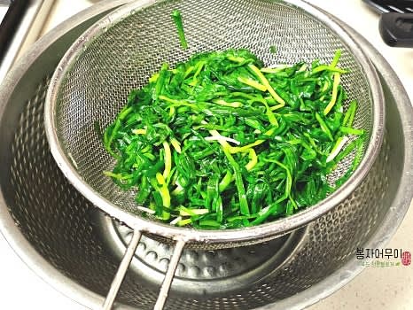 찬물에 부추를 헹구고 물기를 짜서 채반에 올려두어 물기를 제거합니다.