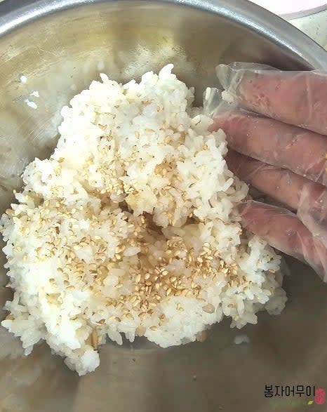 밥에 식초, 소금, 설탕을 넣고 참기름을 추가해 골고루 섞어줍니다.