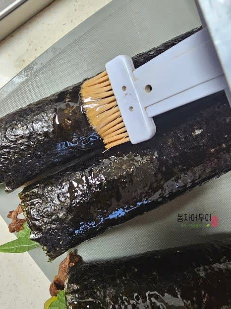 김밥 끝을 참기름으로 고정하고 먹기 좋은 크기로 썰어 접시에 담습니다.