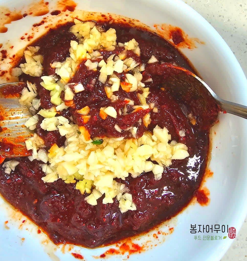 오징어볶음 양념 소스를 만듭니다. 고추장 2스푼, 고춧가루 1스푼, 설탕 1스푼, 매실청 1스푼, 간장 1스푼, 참기름 1스푼, 다진 마늘과 생강을 섞어 30분 이상 숙성합니다.