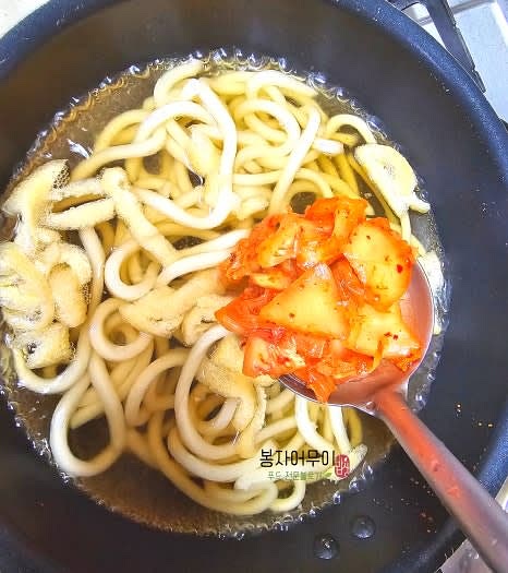 끓는 우동다시에 유부와 어묵을 넣고 양념해둔 김치를 한 국자 넣어주고 잠시 끓여줍니다.