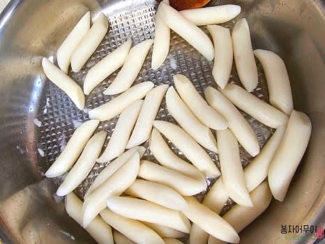 프라이팬에 기름을 두르고 떡볶이 떡을 살짝 볶다가 어묵과 야채를 추가합니다.