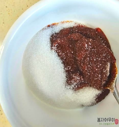 물과 함께 고추장, 설탕, 다진 마늘, 고춧가루를 넣고 섞습니다.
