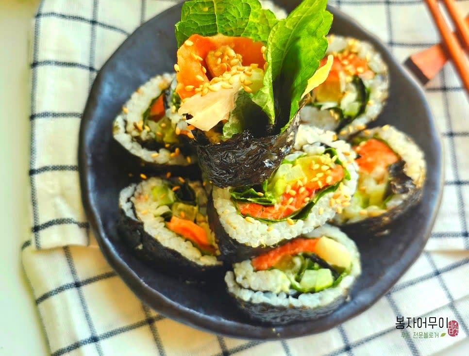 완성된 김밥을 칼로 잘라 접시에 담아냅니다.