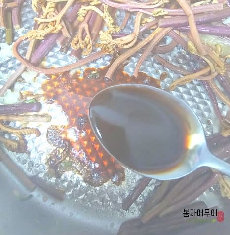 삶은 고사리를 소분한 후, 국간장과 참치 액젓을 넣고 잘 섞습니다.