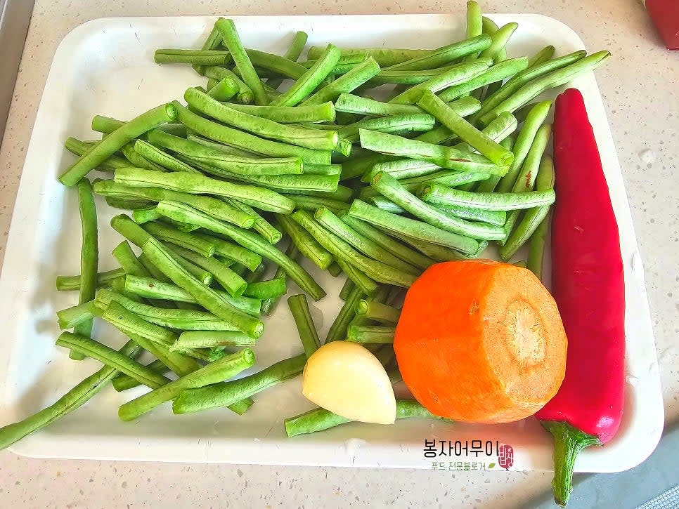 세척한 그린빈을 5~6cm 길이로 자릅니다. 홍고추와 당근은 씨를 제거하고 그린빈과 비슷한 크기로 채 썰어줍니다.